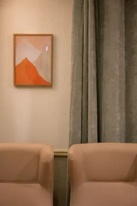 A chair by a piece of orange artwork at Aria Care Home
